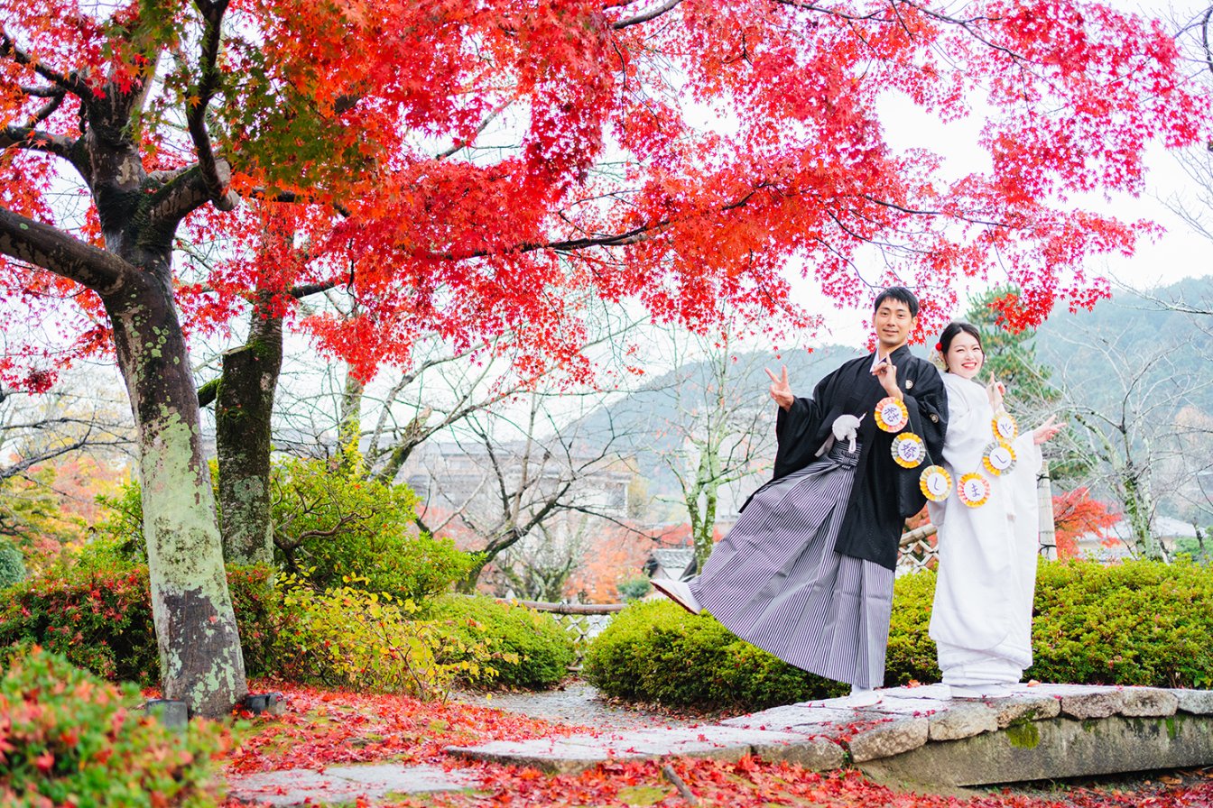秋の紅葉シーズンの嵐山で和装前撮りを行う新郎新婦