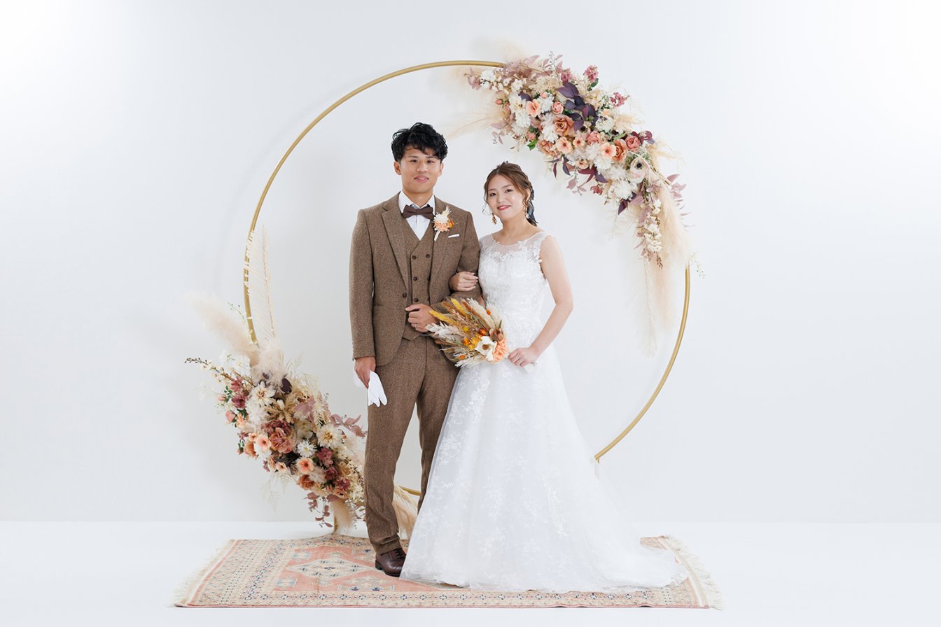 京weddingスタジオのフラワーアーチ背景で洋装前撮りを行う新郎新婦
