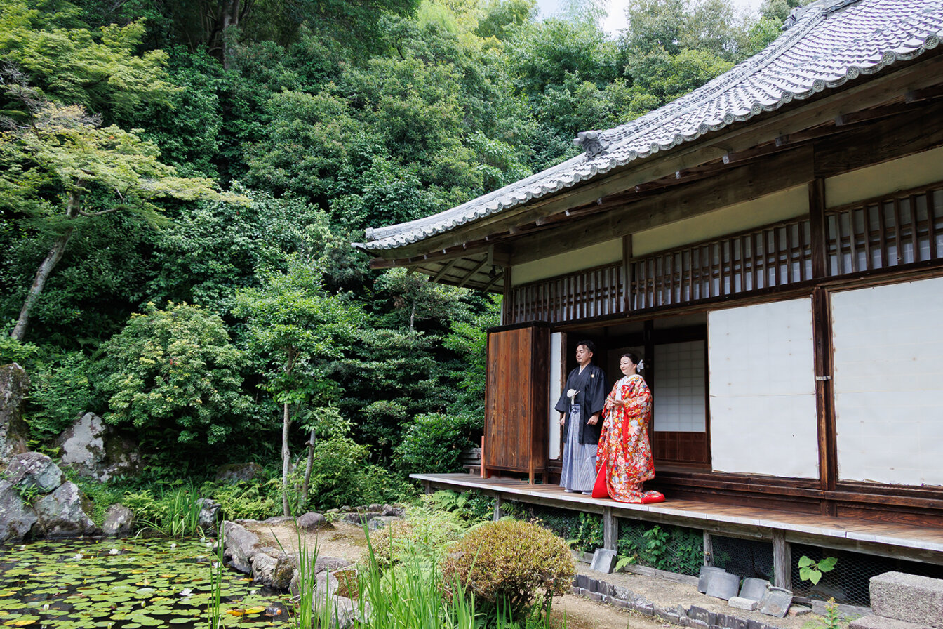 浄住寺の方丈縁側で色打掛を着て前撮りを行う新郎新婦